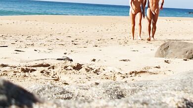 Fitness couple undress on a public beach and masturbate with people watching