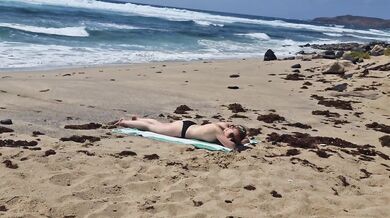 Fille qui bronze seins nus se fait baiser à la plage sur le sable, Naemyia