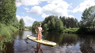 Naked girl on a hiking trip on a SUP board