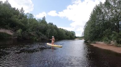 Naked girl on a hiking trip on a SUP board
