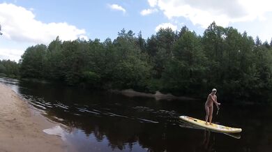 Naked girl on a hiking trip on a SUP board